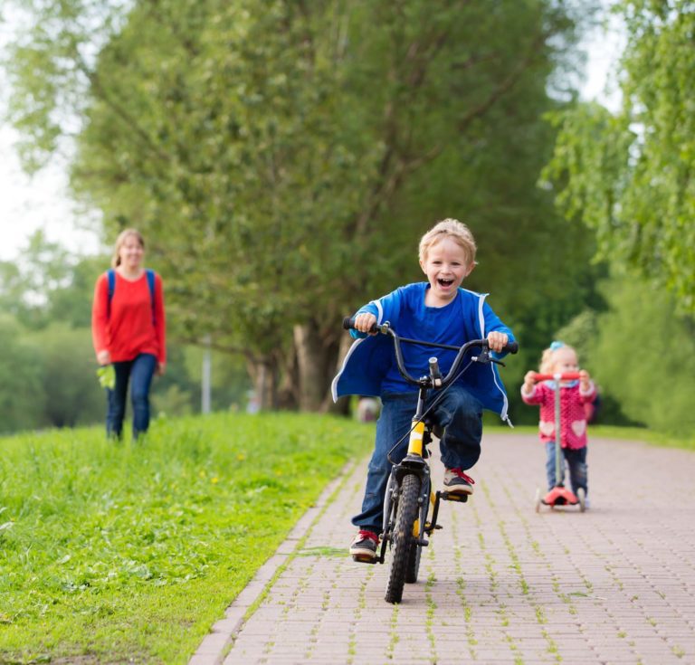 Barn som sykler med resten av familien ute i naturen