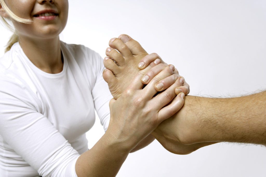 Terapeut som gir behandling gjennom å justere foten