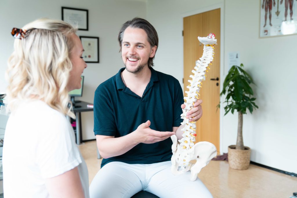 Kiropraktor forklarer med demo av ryggrad